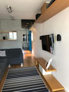 a living room with a couch and a tv on a wall at Apartament Kraków in Krakow