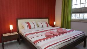 a bedroom with a large bed with pink pillows on it at Villa _Duenen vis a_ vis_ _ strand in Ahlbeck