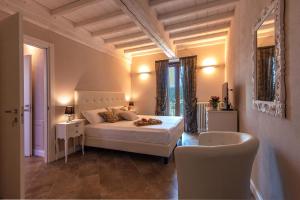 - une chambre avec un lit blanc et une chaise dans l'établissement Borgo di Villa Cellaia Resort & SPA, à Dicomano