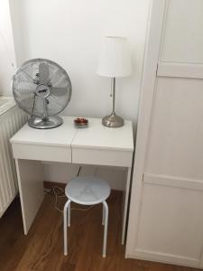 a white desk with a fan and a lamp at Apartman Allegria in Zagreb