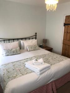 a bedroom with a large bed with towels on it at Bay View Guest House in Beer