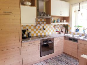 cocina con armarios de madera y horno en Ferienhaus Niedernsill, en Niedernsill