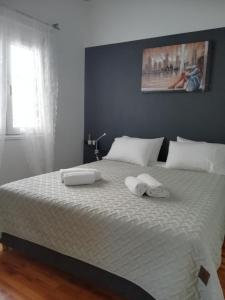 a bedroom with a large bed with two towels on it at Black & Yellow Apartment at City Center in Ioannina