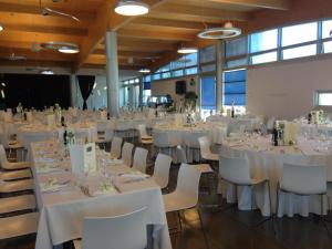 un salón de banquetes con mesas y sillas blancas en Chiaroscuro, en Belforte del Chienti