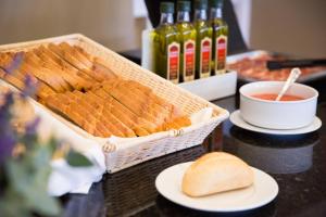 una mesa con una cesta de pan y un tazón de salsa. en Hotel Jerez & Spa, en Jerez de la Frontera