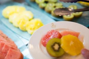 a white plate with fruit on a table at Hotel Jerez & Spa in Jerez de la Frontera