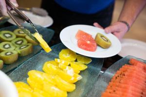 una persona che tiene un piatto di frutta su un tavolo di Hotel Jerez & Spa a Jerez de la Frontera