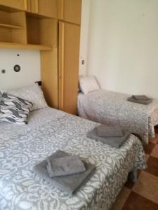 2 aparte bedden in een kamer met een nachtrok bij Villa Natalia in Málaga