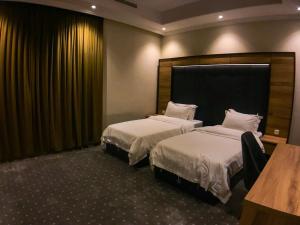 Habitación de hotel con 2 camas y mesa en Lavent Park en Yeda