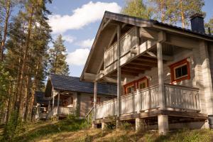 a cabin in the woods with a wrap around deck at Holiday Village Kukkapää in Sulkava