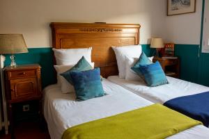 a bedroom with two beds with blue and white pillows at l'abri du viaduc in Saint-Satur