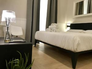 a bedroom with a bed and a table with a lamp at KUKKA ROOMS in Naples