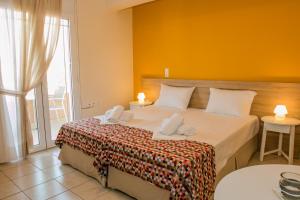 a bedroom with a bed with two towels on it at Sunny Beach Apartments in Rethymno Town