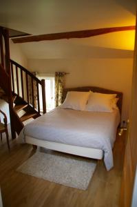 a bed with white sheets and pillows in a room at La Musardine en Vexin in Omerville