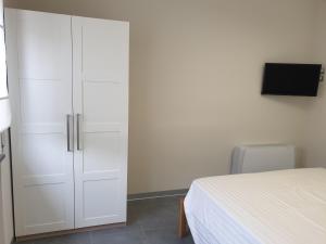 1 dormitorio con armario blanco junto a la cama en Residence Campo Rotondo, en Tavernerio