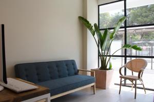 a living room with a blue couch and a plant at YOU & CO. Saler Beach Boutique in Valencia