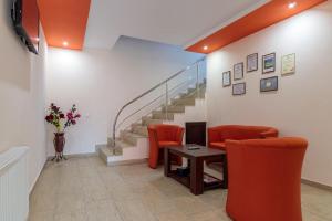 a waiting room with orange chairs and a table and stairs at Pensiunea Arthur in Râmnicu Vâlcea