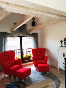 a living room with red chairs and a window at Kuninga 24 Apartment in Pärnu