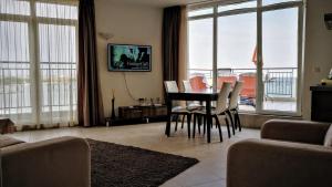 a living room with a table and chairs with a view at AKB Apartment Sea View in Aheloy