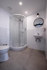 a bathroom with a shower and a toilet and a sink at Hotel Chesscom in Budapest