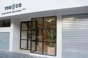 a store front with a display window with a plant at YOU & CO. Saler Beach Boutique in Valencia