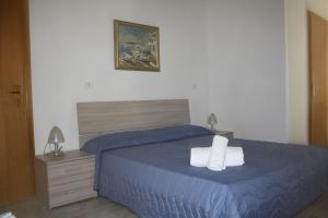 ein Schlafzimmer mit einem blauen Bett mit zwei Handtüchern darauf in der Unterkunft B&B Borgo Pileri in Mazzarino