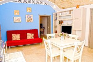 a living room with a red couch and a table at Casetta San Domenico apartment in Monopoli