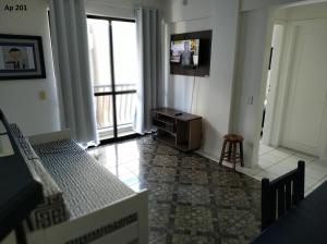 a bedroom with a bed and a tv and a chair at Goldani Lexus Plaza in Florianópolis