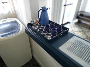 a tray with blue cups on a counter next to a washing machine at Goldani Lexus Plaza in Florianópolis +8 photos