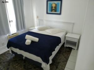 a small bedroom with a bed with a blue blanket at Goldani Lexus Plaza in Florianópolis