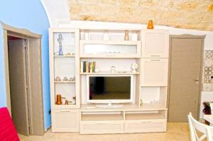 a white entertainment center with a television in a room at Casetta San Domenico apartment in Monopoli