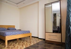 a bedroom with a bed and a large mirror at Apartment Miracle in Batumi
