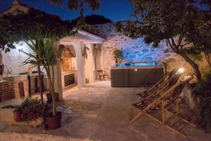 un cortile di una casa con un tavolo e delle sedie di Holiday Home Sudinjevi Dvori a Sukošan (San Cassiano)