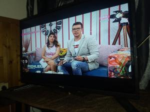 a man and a woman sitting on a couch on a television at Forester in Jošanička Banja