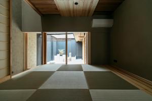 an empty room with a large window and a tiled floor at MACHIYADO 京都南禅寺道 in Kyoto