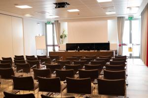 una sala de conferencias vacía con sillas y un podio en Hotel Nazionale, en Matera