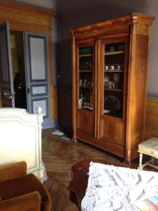 a living room with a wooden cabinet and a couch at Château de Vallègue in Vallègue