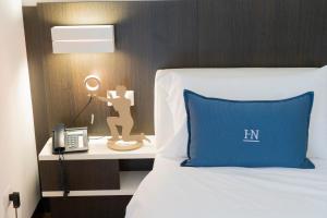 a bedroom with a bed with a blue pillow and a lamp at Hotel Nazionale in Matera
