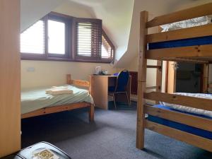 a bedroom with two bunk beds and a desk at FSC Slapton Ley Hostel in Kingsbridge