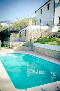 a blue swimming pool in front of a house at La Estancia in El Bosque +4 photos
