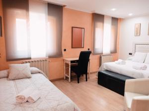 um quarto de hotel com duas camas e uma secretária em Hotel Los Toreros em Tordesilhas
