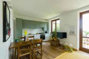 uma cozinha com armários verdes e uma mesa e cadeiras em Discesa a Lago with terrace and garden on lake Iseo em Riva di Solto