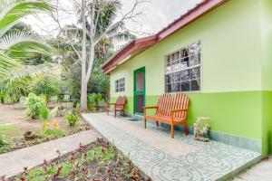 una casa verde con 2 sillas en el porche en Midas Belize, en Trapiche