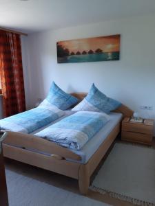 ein Schlafzimmer mit einem Bett mit blauen Kissen in der Unterkunft Ferienwohnung Viktoria in Lenzkirch
