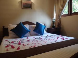 a bed with red rose petals on it at Alfred Colonial Bungalow & Spice Garden in Kobbekaduwa