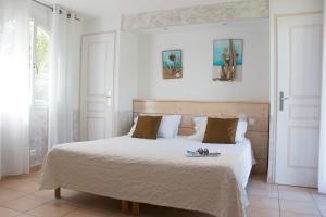 a white bedroom with a bed with a tray on it at Hotel Les Flots Bleus in Le Lavandou