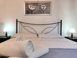 una camera da letto con un letto e asciugamani di La Casa dei Girasoli a Marzamemi