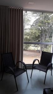 dos sillas sentadas frente a una ventana en Recanto Silveira Minas, en Capitólio
