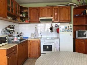 a kitchen with wooden cabinets and a white refrigerator at Апартамент Вангелов in Nesebar