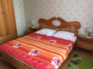 a bedroom with a large bed with flowers on it at Апартамент Вангелов in Nesebar